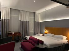 Deluxe King room with rollaway bed; full-sized desk, couch facing TV, and additional chair 