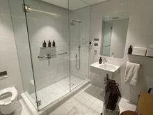 Shower Number 1! After a long day, I decided to shower before the 10 hour flight to LHR. Quantas F lounge shower: Old school tiles, but did the trick. I wish they had a luggage rack, instead of using the ottoman. Space was decent. 