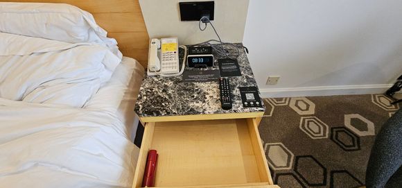 Bedside drawer with emergency torch.
Clock needs covered up as a little bit of light at night.