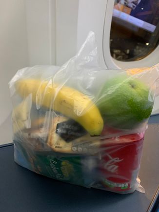 And a large plastic bag of 3 mini water bottles, mini Coke can, banana, apple, and a bunch of crackers, biscuits, and candy..same bag for everyone in J and Y. 