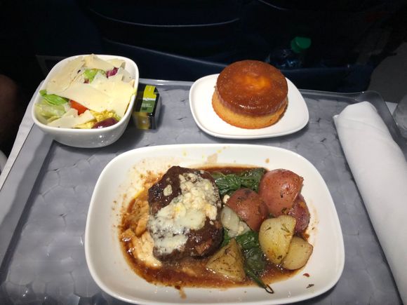 I've done this flight enough to know they'll load eight steaks and eight mediocre salads, so I sacrificed an aisle seat to make sure I was in the first two rows.  I enjoyed the steak with the blue cheese topping, and the apple cake was excellent.  I feel bad for the last two rows who got stuck with the potato salad.