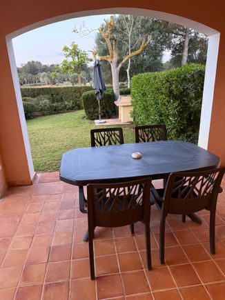 the outdoor area with table and chairs and an outdoor grill