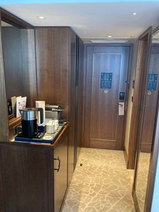 Look into the entry vestibule, left the minibar, kettle and Nespresso coffee machine and closet, right the bathroom