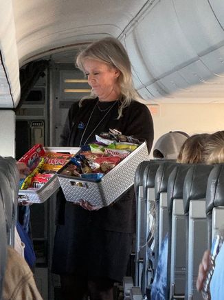 VP of Inflight for DAC (and our F/A that day) with what is the best snack basket in the industry. Flight was full of city and county execs, those of us who helped, etc. 