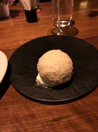 Coconut, while chocolate and almond outer shell enclosing a scoop of ice cream