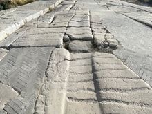 Ruins of a Cassis-stone paved road dating to the 2nd-4th C BC. The grooves make the pavement less slippery for horse carriages. There's an older pebbled road underneath.