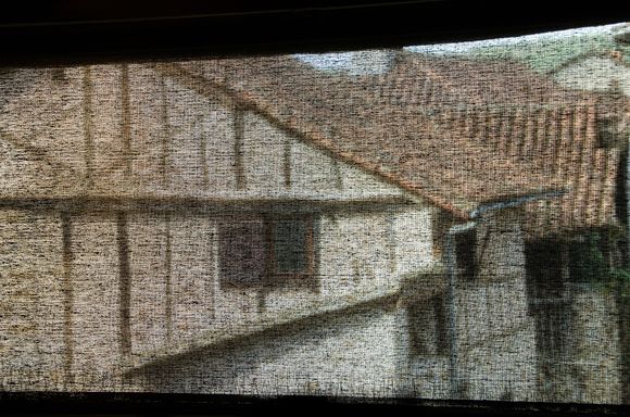 View to outdoors through gauzy screen inside Champollion Writing Museum.