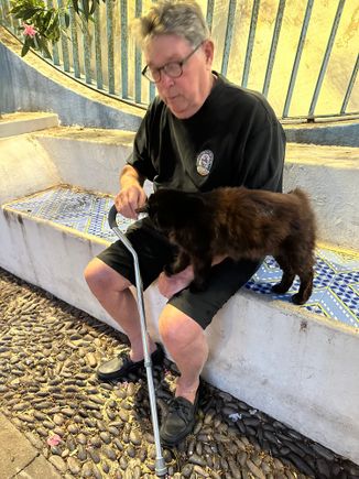 80 year old man with cane on Salina, with cat