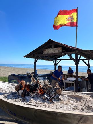 open charcoal fire on the "boat" where they grill the fish