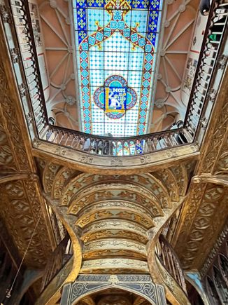 Looking up at the stairs and stained glass ceiling at Livraria Lello