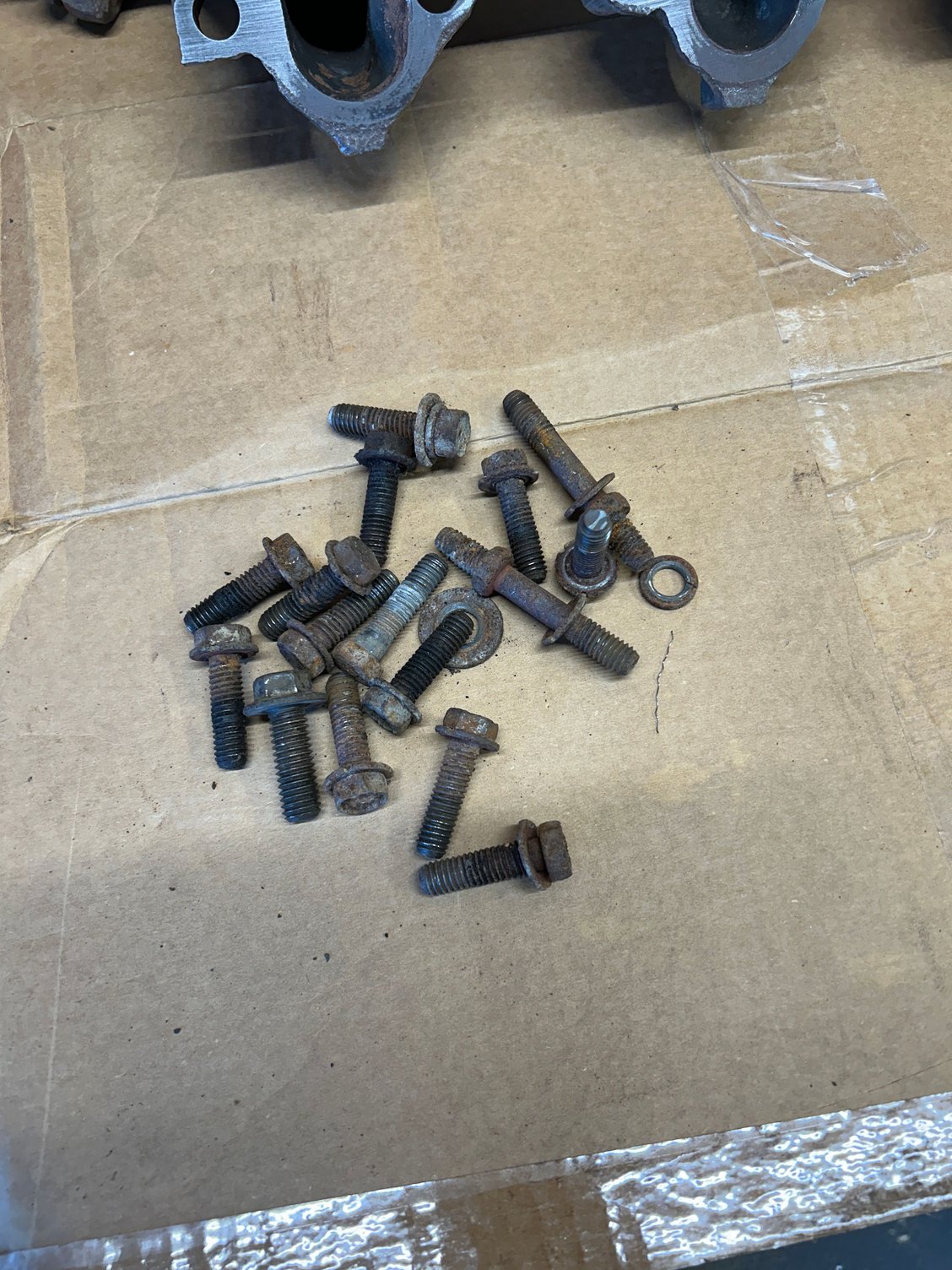 Next, I grabbed all the bolts and then I started up with the wire wheel on the bench grinder. They turned out OK and yes, I�m just reusing them. I�m not buying new ones. I ended up installing them with a little bit of anti-seize on them so hopefully they won�t get rusted and stuck in there. I may replace them later and it will be nice to get them out easier
