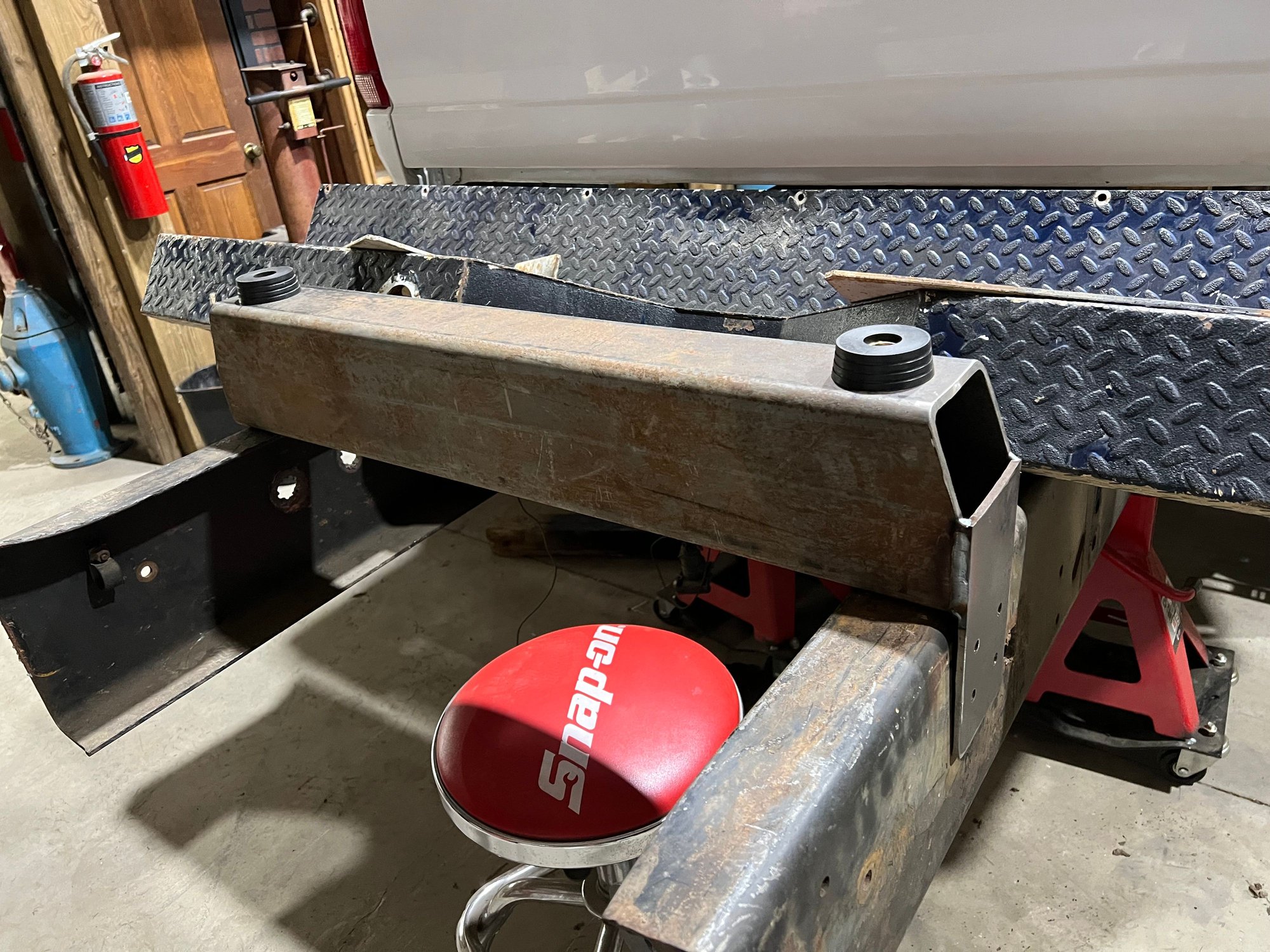 I welded plates on the bottom half of the tube with 4 - 3/8 inch holes to bolt to the frame. I left the opening on top to access the bushing, nut and washer. I plan to drill holes in bottom corners of the plate to allow the tube to drain. I�ll paint it with frame paint I�ve got from another project.