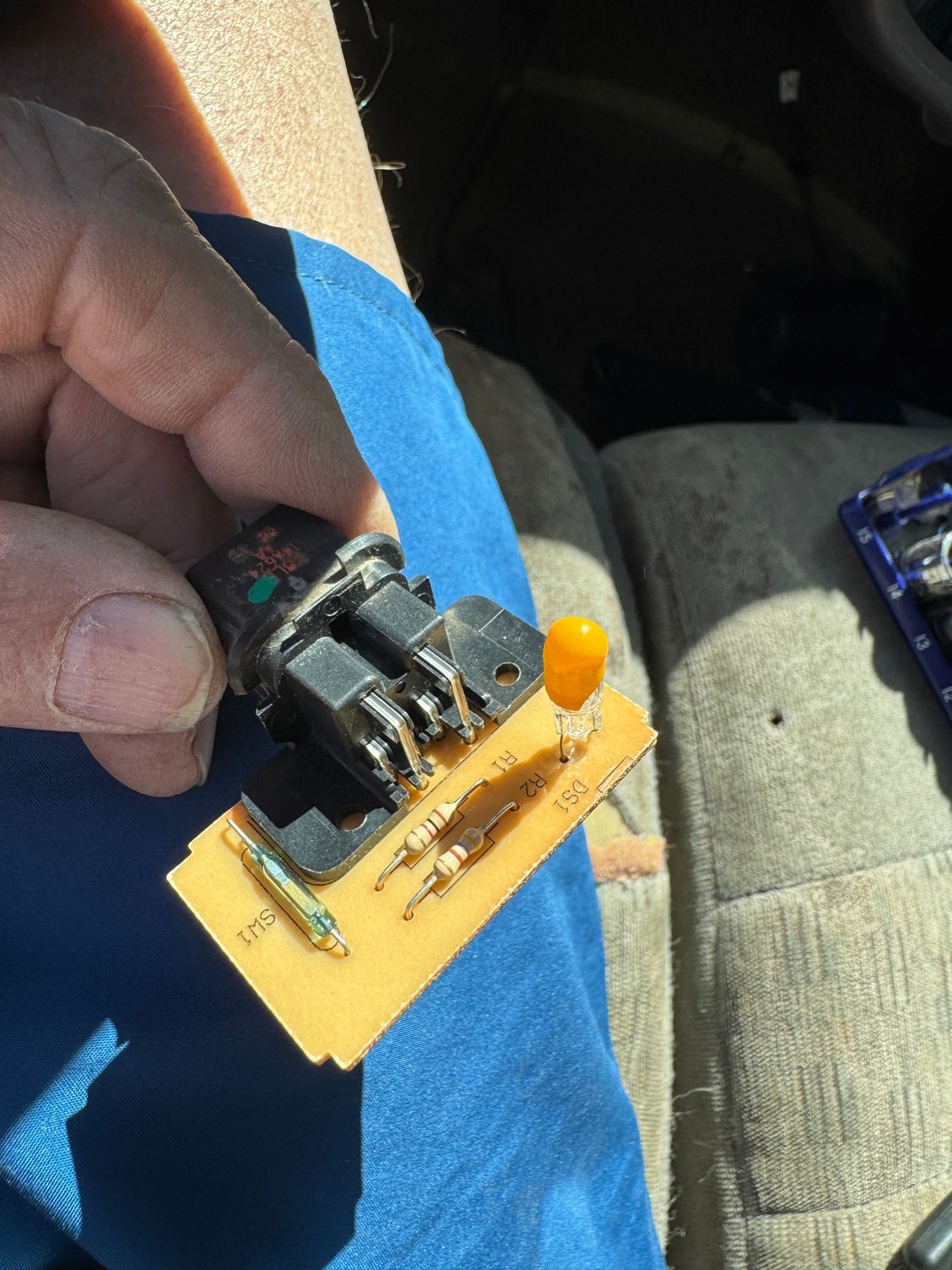 Here’s the small circuit board with a small bulb soldered in.  Note a thin plastic sleeve over the glass bulb.  If this bulb is burned out then the dash airbag light throws the 27 code.