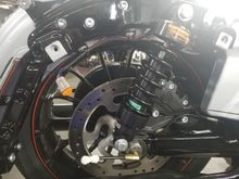 The little white thing near the axle is the air line quick disconnect from the compressor that lives in the saddlebag.  The orange thing is the electrical connector. 