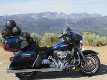 Small luggage bag, sleeping bag and tent on luggage rack.  Rain gear and air mattress on back seat.