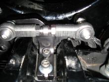 Here is a pic from the floor looking up at the rear TT unit installed. 2nd TT bracket attaches to rear motor mount with supplied longer bolts. Use adj nut in center of link to adjust 'tension' - not too tight/loose - then tighten lock nuts.