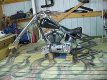 Trike 004 
Here we moved the bike to my buddies shop (Billy) He will be the one that does the painting. After we got it set in place we hung the forks on. There is no neck bearing in yet at this point but I just had to see the front end on the bike. We also started to play with the seat position an the tank mounting position as well. We will get back to that when we mount the new air bags and get the seat in its final resting place.