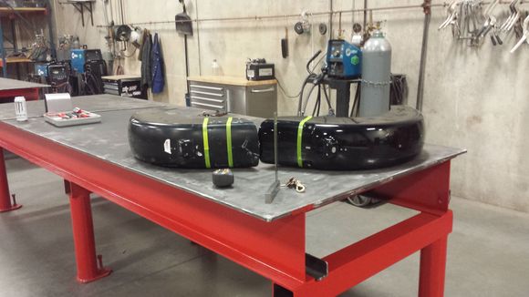All laid out on the nice work surface. In order to run the upper tape line, I laid one on top of the other and taped straight across both. This would ensure that both fenders would be cut in roughly the same place.