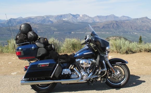 Small luggage bag, sleeping bag and tent on luggage rack.  Rain gear and air mattress on back seat.