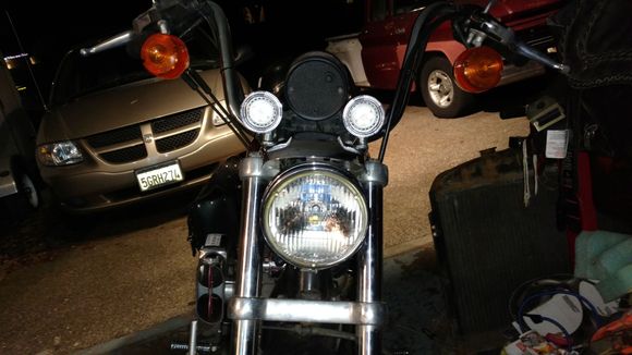 Mounted a couple of 50W LED running lights.  I used a couple of old Dyna turn signals that I gutted and added the LEDs to. They are wired into the aux lighting in the headlight bucket.  Front View