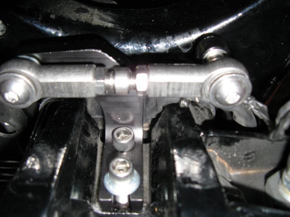 Here is a pic from the floor looking up at the rear TT unit installed. 2nd TT bracket attaches to rear motor mount with supplied longer bolts. Use adj nut in center of link to adjust 'tension' - not too tight/loose - then tighten lock nuts.