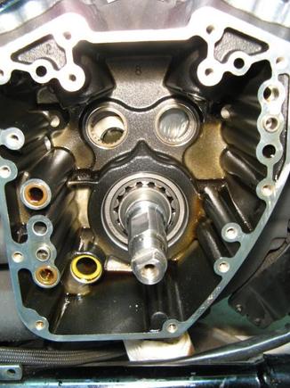 With cam support plate removed can now access cam bearings. Flywheel can be seen just behind bearings. Note oil passage o-rings on left - must change during install no matter how many miles on motor.
