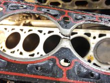 The failed gasket lifted from the block and flipped upside-down.  Note exhaust-side cyl 2 compression ring and coolant passage failures in top right.