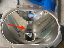Driver's side reflector bowl: The arrow points to a dull area. When reinstalling, I flipped this so that the light being projected to the road is from the non-burnt reflective end. 