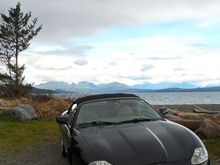 Miss V at Rebecca Spit with the Coastal Range on mainland Canada behind along with a number of islands.