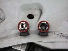 Stepping through the internal removal.  The left one has the bulb removed, the right one has a 1/2" hole drilled through it and the metal topper removed.  Note, there is still the 3 tabs to secure the holder to the fog light housing.  DO NOT!!!! remove these 3 tabs.