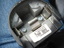 Rearview mirror housing shown from top. this entire piece is solid metal. in the center you see the stainless steel piece with three springs sticking up - one in the center allows the retaining ring to slide over it, and two on either side that catch the grooves on the sides of the retaining ring.