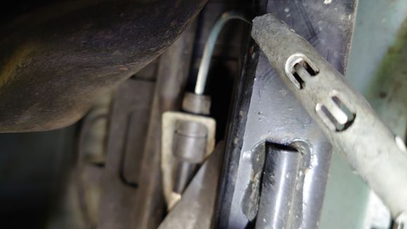 Retaining bracket bottom side. Tangs visible need to be bent back to remove cable.