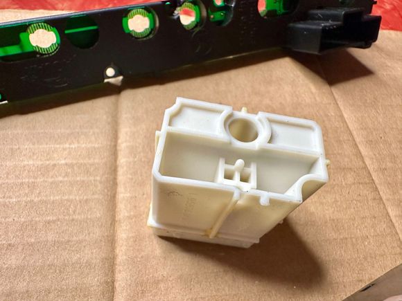 The nub between the 2 small squares is what presses the underlying button (rear view of inner button).