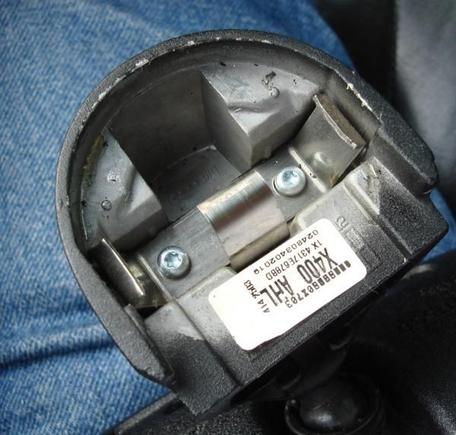 Rearview mirror housing shown from top. this entire piece is solid metal. in the center you see the stainless steel piece with three springs sticking up - one in the center allows the retaining ring to slide over it, and two on either side that catch the grooves on the sides of the retaining ring.