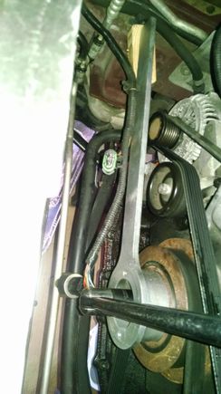 I am removing the crankshaft bolt.  I braced the tool with a piece of wood as shown.  I used a two foot long 1/2" drive breaker bar with a two foot pipe slid over the end.  You need at least three feet of leverage.