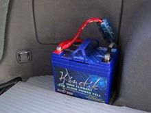Kinetik Car Battery in Rear.
Must have Fuse/Breaker before this battery and also at front main battery as a safety precaution if you ever get T-Boned from side