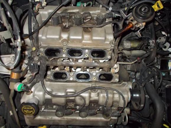 V6 engine replacing sparkplugs and fixing wire on coil pack.