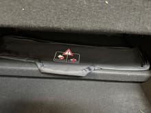 Wind deflector case in trunk where it naturally sticks with velcro to floor