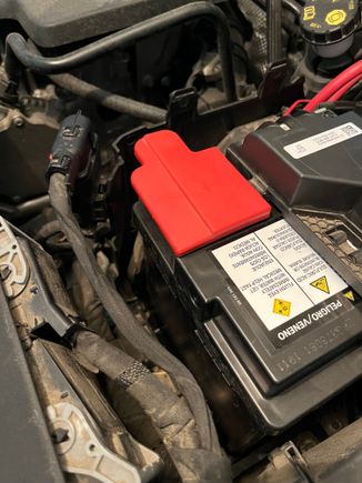 remove and keep the red positive terminal cover to use on the new battery.