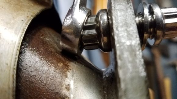 In turning the bolt around so the nut is in the front, still, you can't use 12 point without maybe a flare nut so I made a rounded punch and with the cat bolted down by the flange in a vise, punched a small dimple just enough to pass the 1/2" box end 12 pt wrench on the nut and still be able to remove it after tightening/ torquing.