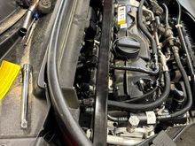Coils are under the cross bar, almost under the cowling.  Had to snake the plug socket and extension between the two.