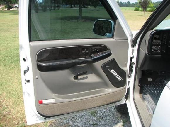 charcoal woodgrain door trim, leather wrapped arm rest, and bose speaker grills