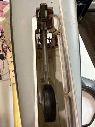 Notice two small holes in fuse near relief to allow use of a ball driver to secure rear of retract.