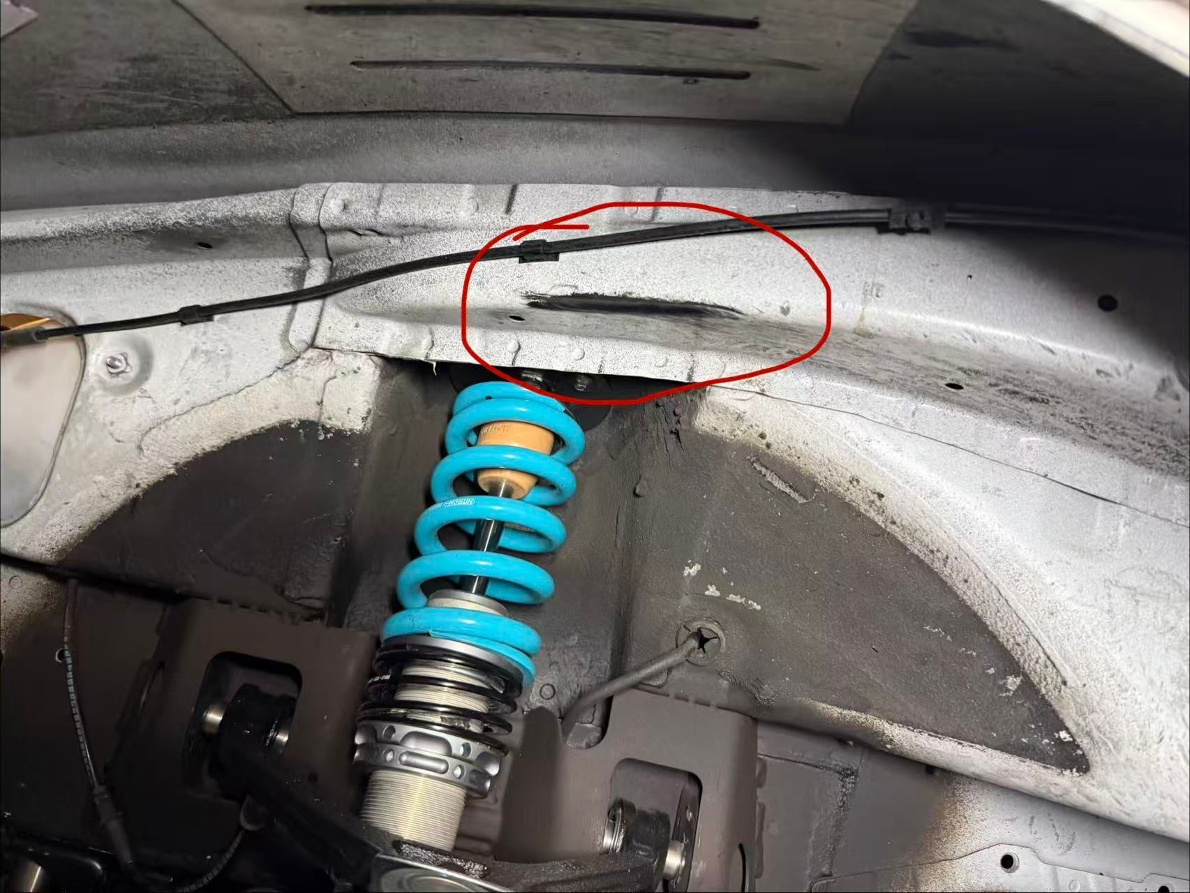 This is the part I am talking about on the front of the frame, contacting the tire during high-speed cornering. That is why the right bump stop length is essential. 