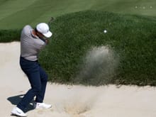 Jason Day practicing in a sand trap.
