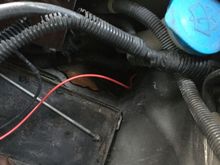 The wire goes through the firewall underneath the windshield spray tank.