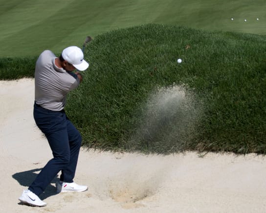 Jason Day practicing in a sand trap.