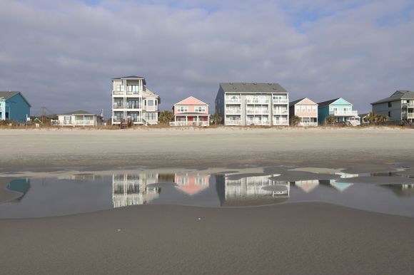 Reflection of beach houses in a tidal pool