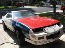Yes it's ugly.  The car had been horribly Earl Shive'd at some point in white over the original Bright Red, and no care had been taken to mask off body seals.  Most of it flakes off if you run your hand over it.  The fender and hood are from the junkyard, hence the mismatch in color.  I picked up the car for $300 with a clear title, and the only thing it was lacking was the hood.  The last owner rear ended a truck, hence the missing hood, replacement fender, and cracked windshield.