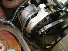 All of it bolted to the front of the engine.  It actually fits quite well and seems very sturdy.  there's miles of adjustment in that bracket, unlike the one that was on there before (the difference between bought parts and designing your own).  

The original belt was a 360K6 (36" long, 6 rib) but I couldn't get that on the pulley even crushing the lower radiator hose.  I looked in my pile of old belts and found a 370K5 (1 inch longer, 37" long,but only five ribs), which I could JUST BARELY